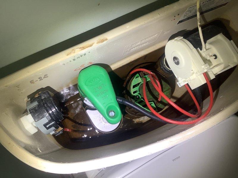Responded to service call for toilet repair in a 126-year-old home. Upon inspection, found faulty flush mechanism in TOTO toilet with visible mineral deposits at waterline. Replaced green float valve and repaired electrical components of flushing system, restoring proper function to the bidet toilet.