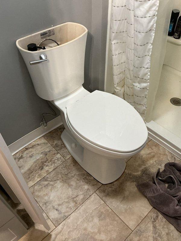 Diagnosed and repaired a leaking toilet in a 65-year-old home, replacing worn internal tank components. Observed significant water damage and staining around the floor drain, indicating long-term leakage that had caused deterioration of the surrounding tile area. Completed full flush test after repair to verify proper operation and no further leakage.