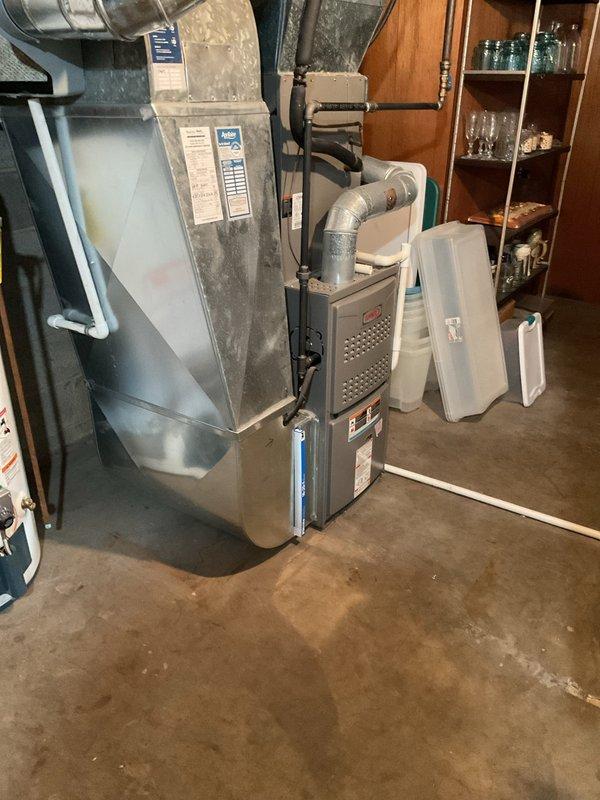 Responded to water leak complaint in basement. Inspected HVAC system including furnace with connected ductwork and humidifier unit. Discovered hole in condensate line causing water accumulation; repaired damaged section and verified proper drainage function to resolve the leak issue.