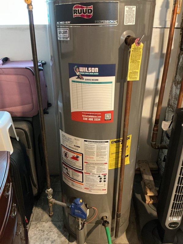Performed scheduled water heater flush service on Ruud Professional tanked water heater. Connected drainage hose to bottom valve and thoroughly flushed system to remove sediment buildup. Inspected unit, connections, and expansion tank for proper operation after service completion.