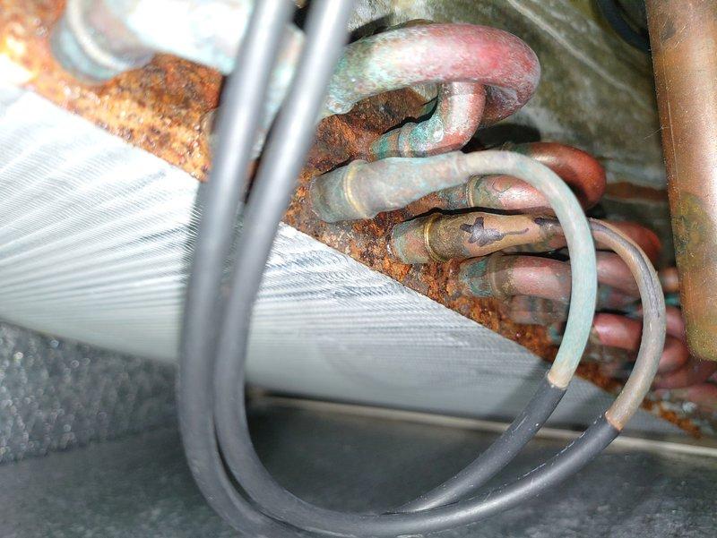 Performed leak search on A/C unit in conjunction with scheduled maintenance. Identified significant corrosion and oxidation on copper refrigerant lines with visible rust formation at connection points. Documented extensive deterioration of coil assembly for potential warranty claim.