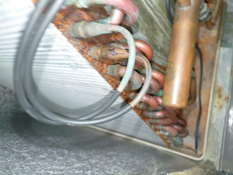 Performed leak search on A/C unit in conjunction with scheduled maintenance. Identified significant corrosion and oxidation on copper refrigerant lines with visible rust formation at connection points. Documented extensive deterioration of coil assembly for potential warranty claim.