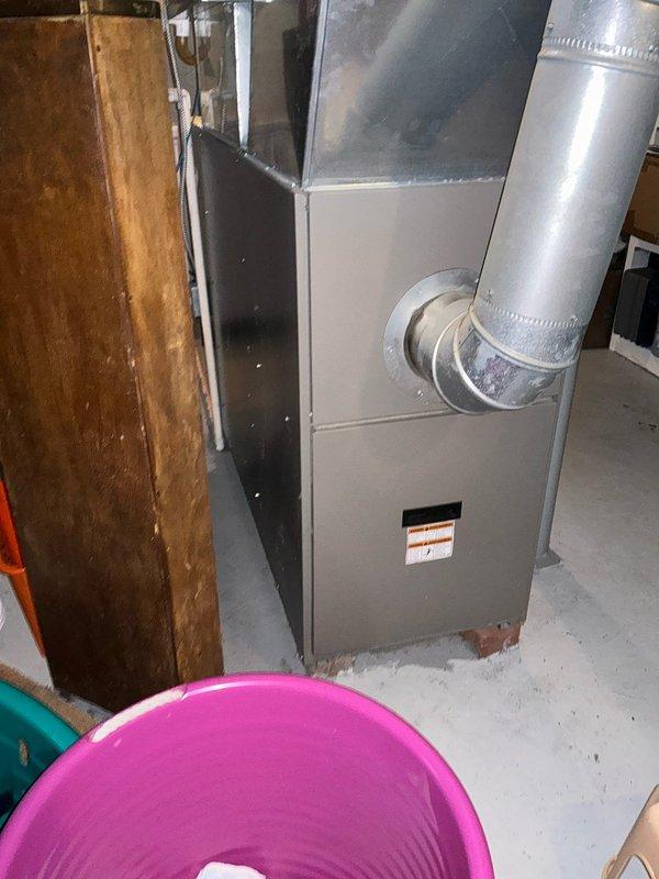 Performed evaluation of aging HVAC system including 18-year-old oil furnace and 16-year-old heat pump. Documented current equipment condition with photos showing basement-installed furnace with connected ductwork and the exterior heat pump unit mounted on concrete pad. Prepared replacement estimate for complete system upgrade.