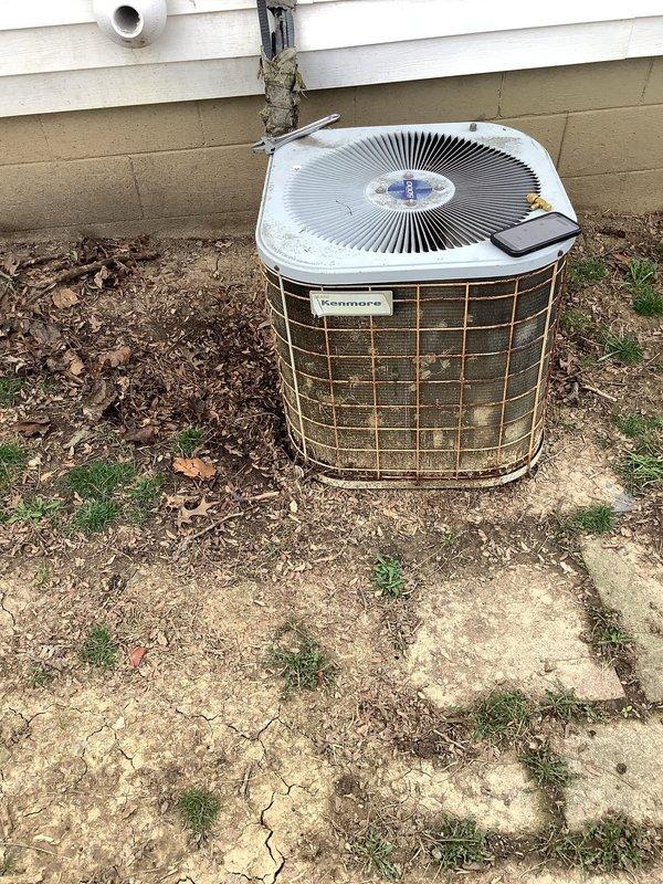 Performed scheduled maintenance on Kenmore outdoor air conditioning condenser unit. Observed significant dirt accumulation, debris, and corrosion on exterior components including protective grilles and housing. Documented condition with photos for service record.