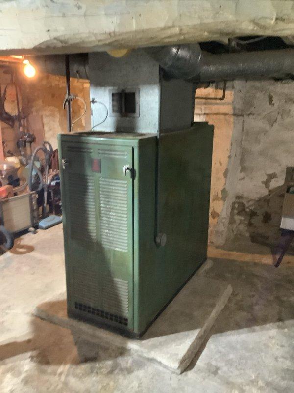 Completed installation of a new 80,000 BTU furnace system with 600 CFM capacity in residential basement utility area. Removed aging green furnace unit and installed new system with proper connections to existing ductwork. System was properly calibrated, tested for optimal performance, and all debris was removed from the work area.