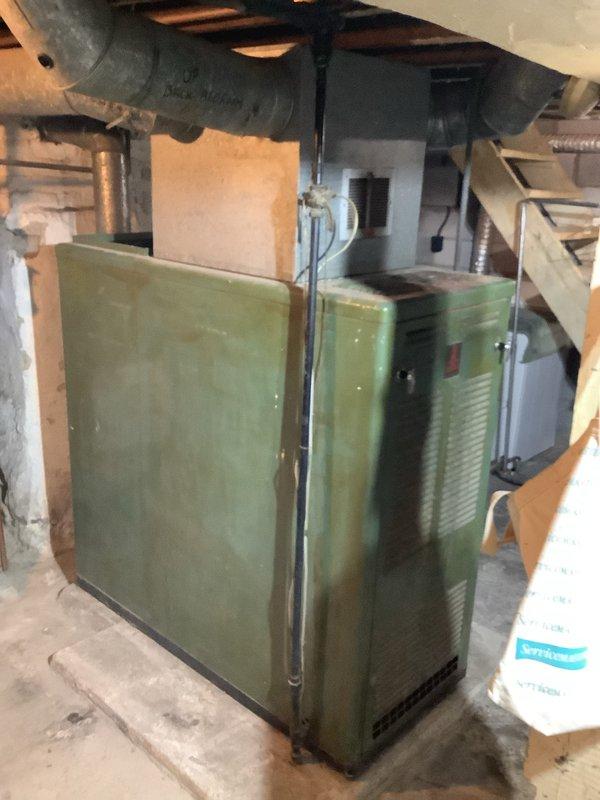 Completed installation of a new 80,000 BTU furnace system with 600 CFM capacity in residential basement utility area. Removed aging green furnace unit and installed new system with proper connections to existing ductwork. System was properly calibrated, tested for optimal performance, and all debris was removed from the work area.