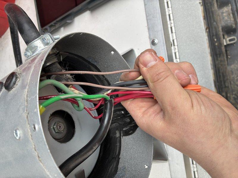 Successfully completed electrical hard-wiring installation for a replacement dog grooming dryer unit. Disconnected existing wiring from previous unit, then properly connected new dryer using appropriate wire connectors to join color-coded conductors (green, red, white, and black) within the metal housing, ensuring secure electrical connections and proper grounding.