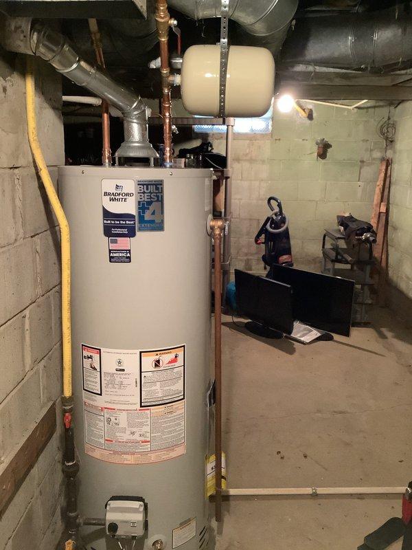 Successfully replaced existing 40-gallon water heater with new Bradford White 40-gallon tall model. Installation included new water shut-off valve and expansion tank with 10-year warranty. All components were properly connected to existing copper piping system in utility room.