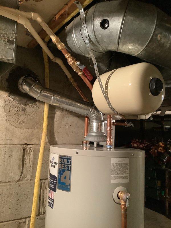 Successfully replaced existing 40-gallon water heater with new Bradford White 40-gallon tall model. Installation included new water shut-off valve and expansion tank with 10-year warranty. All components were properly connected to existing copper piping system in utility room.