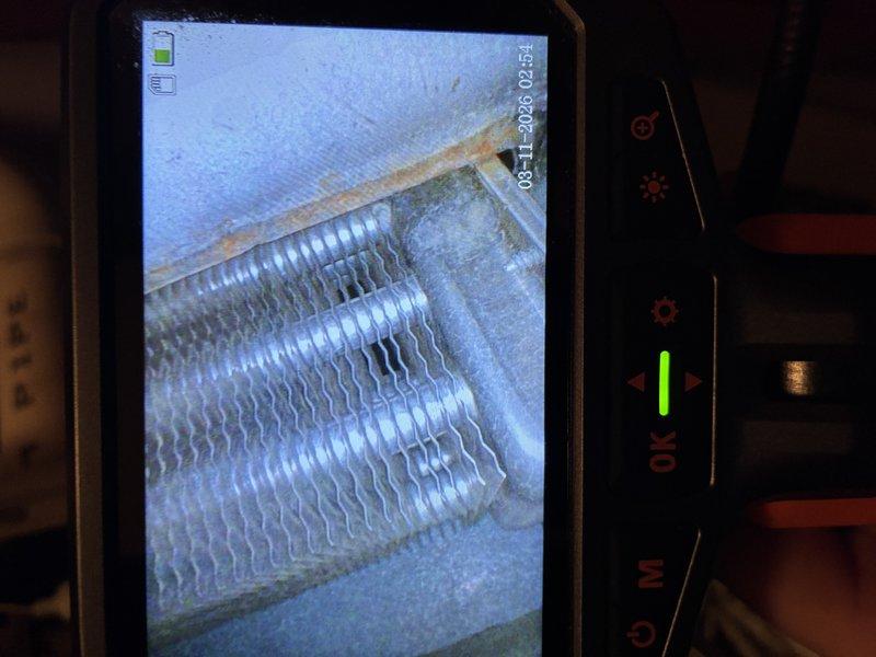 Performed routine maintenance on two 21-year-old gas furnaces installed in 2005. Inspection revealed heat exchanger with visible corrosion along the top edge, and identified exposed insulation with deterioration near electrical connections. Completed full system tune-up and recommended monitoring of heat exchanger due to age-related wear.