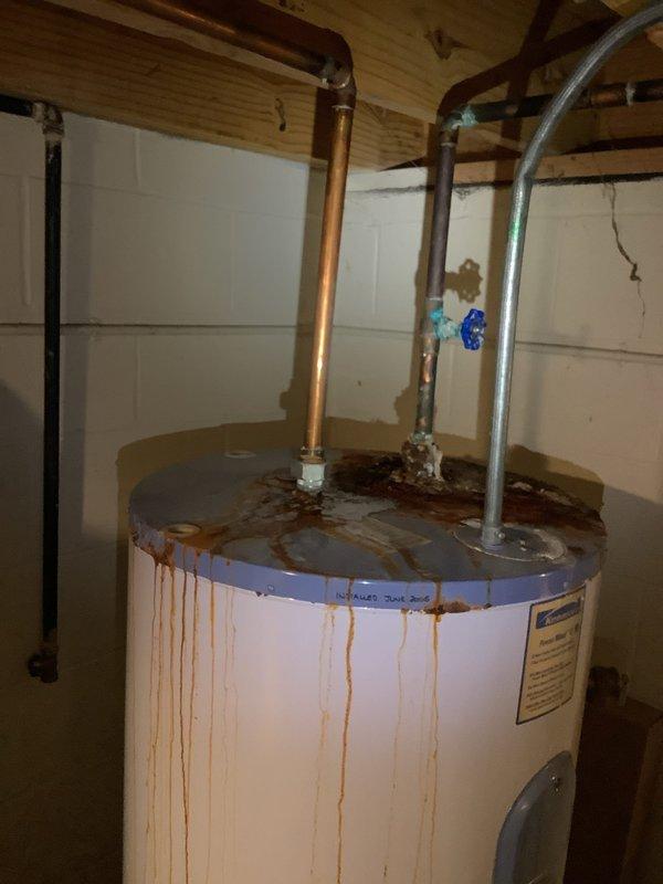Replaced severely corroded 80-gallon electric water heater that was actively leaking from tank. Also repaired leaking outdoor spigot by replacing valve assembly and securing copper supply line connection in ceiling joist area where damaged insulation was observed.