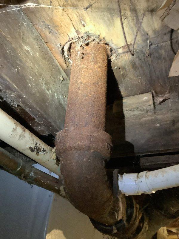 Successfully replaced severely corroded 4" cast iron waste pipe system that was showing extensive deterioration. Cut out damaged sections beyond vent tie-ins, rebuilt with new PVC piping to properly service the bathroom group (lavatory, shower, and toilet). Installed new 4" PVC flange with additional wood reinforcement to create secure mounting point for toilet installation.
