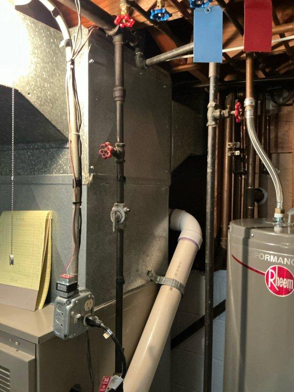 Conducted inspection of aging HVAC system including Rheem Performance water heater, furnace unit, and associated plumbing components in basement utility area. Evaluated existing installation consisting of copper/PVC piping network, electrical connections, and condensate drainage system to prepare comprehensive replacement estimate for both furnace and air conditioning units.