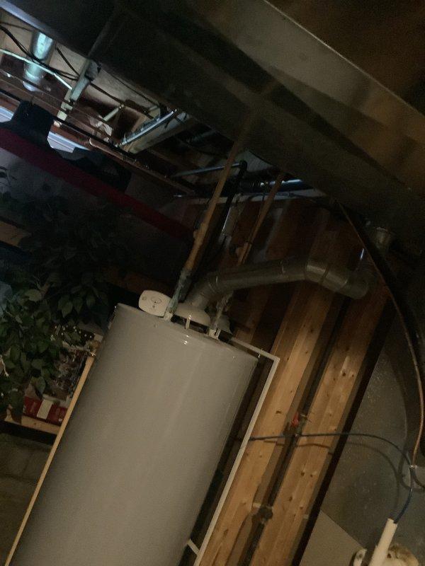 Performed comprehensive assessment of aging HVAC system requiring replacement. Inspected water damage to existing unit caused by previous well pump failure. Documented plumbing infrastructure and water heater setup in unfinished basement area with exposed wooden framing. Provided customer with furnace and air conditioning replacement estimate with installation options.