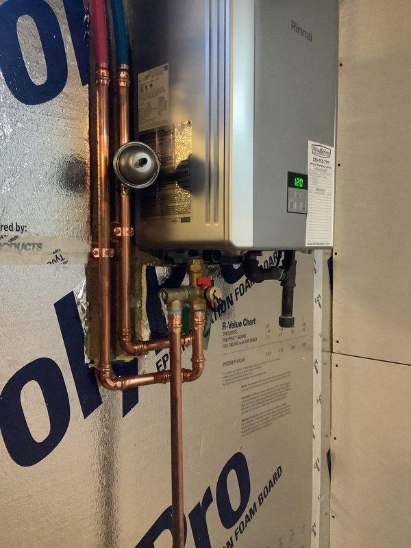 Completed installation of new Rinnai RE180IN tankless water heater, replacing customer's 2008 Rinnai RL75 model. Additionally installed water softener system on exterior wall adjacent to main water closet, with proper connections made after the irrigation system and discharge drain routed to downspout pipe via core drilling through exterior wall.