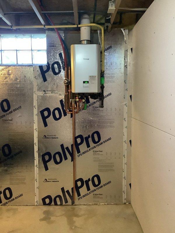 Completed installation of new Rinnai RE180IN tankless water heater, replacing customer's 2008 Rinnai RL75 model. Additionally installed water softener system on exterior wall adjacent to main water closet, with proper connections made after the irrigation system and discharge drain routed to downspout pipe via core drilling through exterior wall.