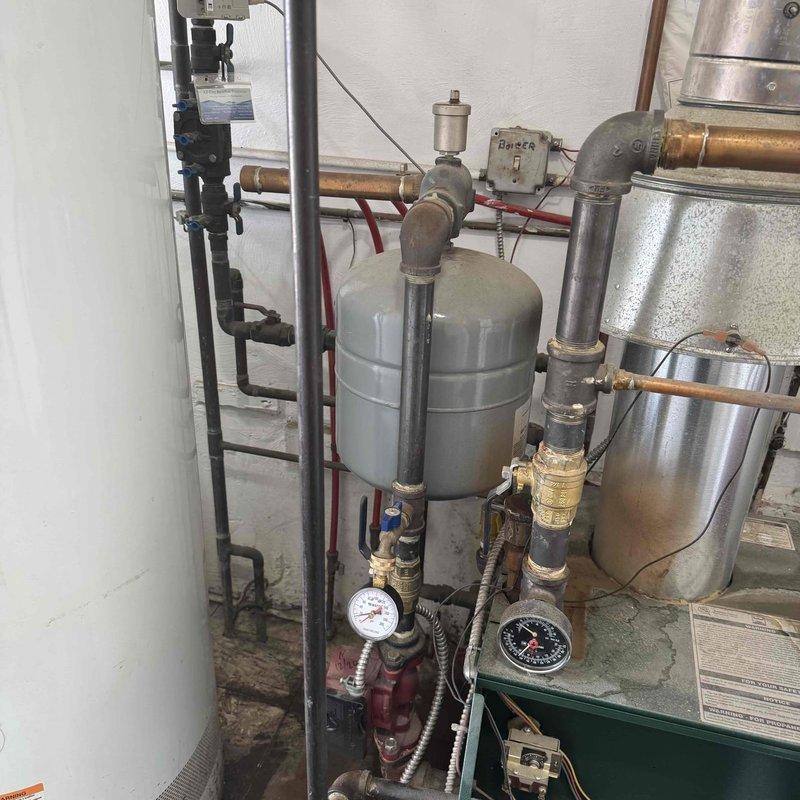 Completed heating maintenance service on boiler system with multiple zone controllers. Inspected expansion tank, pressure vessel, and associated piping components for proper function. Verified all pressure gauges were reading within normal operating parameters and confirmed zone controllers (#1-4) were functioning correctly.