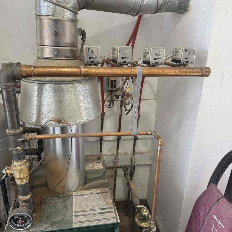 Completed heating maintenance service on boiler system with multiple zone controllers. Inspected expansion tank, pressure vessel, and associated piping components for proper function. Verified all pressure gauges were reading within normal operating parameters and confirmed zone controllers (#1-4) were functioning correctly.