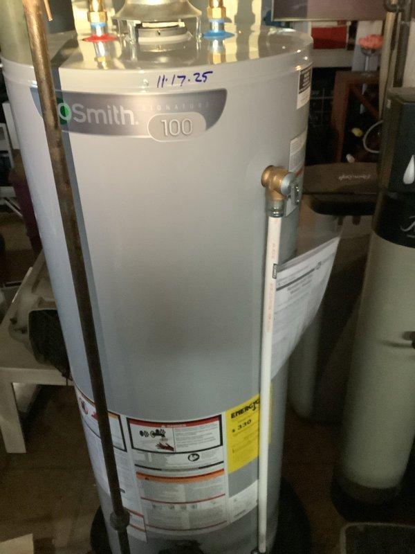 Investigated leak under 18-year-old kitchen sink with suspected dishwasher connection issue. Identified compromised drain hose fitting with inadequate sealing at connection point. Replaced damaged drain hose assembly and secured with proper metal hose clamp to prevent future leakage; also noted A.O. Smith Signature 100 water heater (MVP: 2025) functioning normally during system inspection.