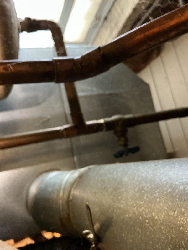 Investigated water leak in basement during scheduled service call. Inspected copper supply lines and ventilation ducting in utility area, noting minor corrosion at pipe connection points. Located source of leak at junction where copper piping interfaces with wall penetration; applied appropriate sealant to resolve the issue.