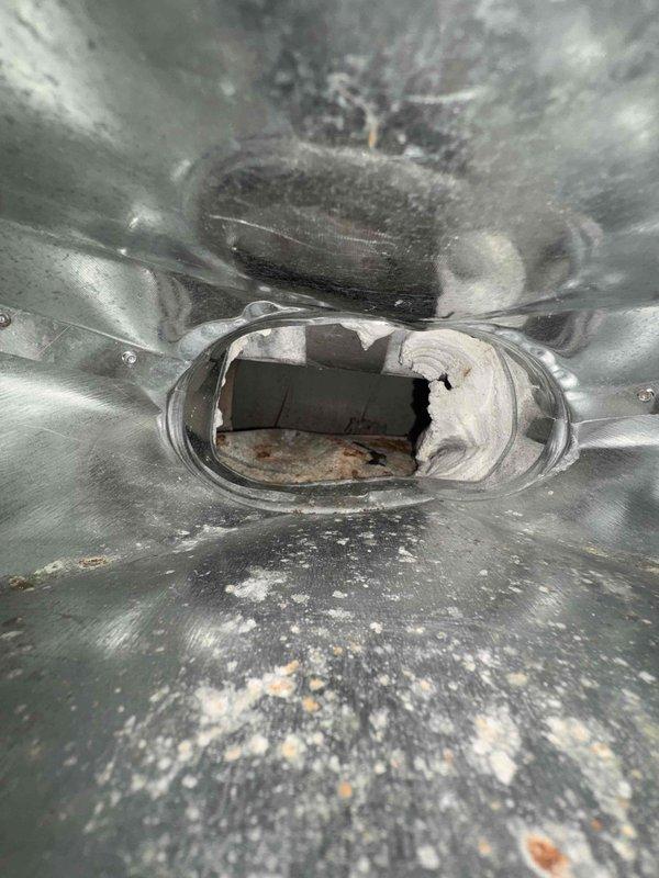 Completed comprehensive duct cleaning service on residential HVAC system, focusing on galvanized sheet metal ductwork that showed significant dust accumulation and minor corrosion. Accessed and thoroughly cleaned crawlspace ducting with wooden ceiling joists above, removing all visible debris and dust deposits from concrete floor areas and duct interiors.