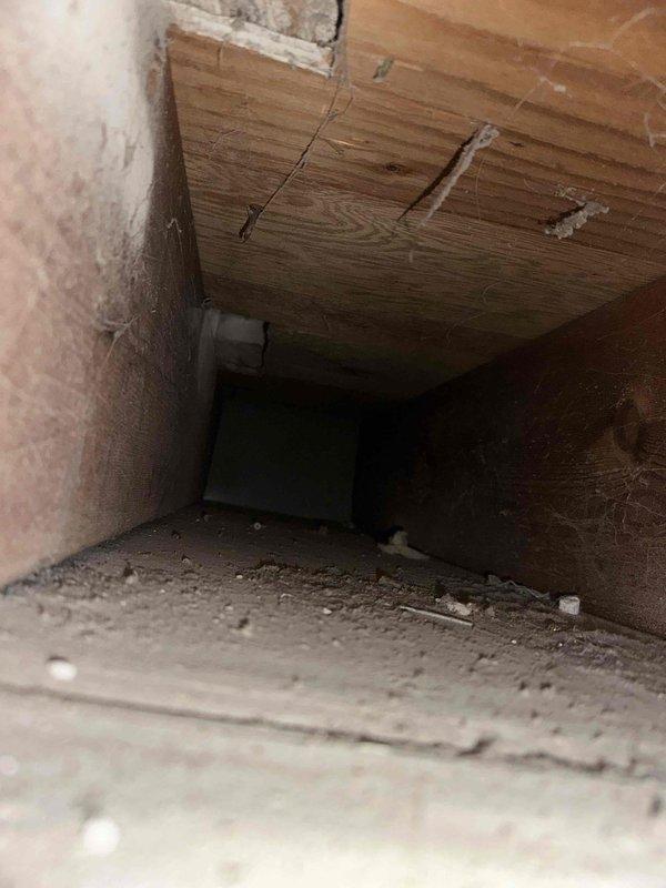 Completed comprehensive duct cleaning service on residential HVAC system, focusing on galvanized sheet metal ductwork that showed significant dust accumulation and minor corrosion. Accessed and thoroughly cleaned crawlspace ducting with wooden ceiling joists above, removing all visible debris and dust deposits from concrete floor areas and duct interiors.
