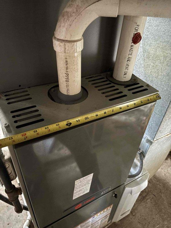 Inspected 11-year-old Trane furnace with confirmed cracked heat exchanger. Documented existing installation including PVC venting, ductwork configuration, and current dimensions for proper replacement sizing. Provided replacement quote for new furnace system.