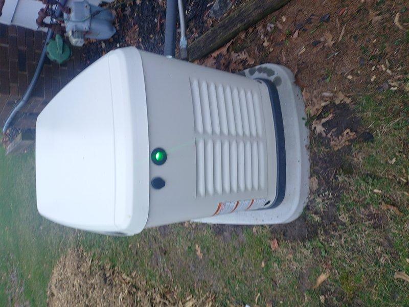 Performed scheduled maintenance on outdoor generator unit including battery terminal inspection and cleaning. Checked all electrical connections and verified proper charging system operation. Unit was successfully tested with green indicator light confirming normal operation status.