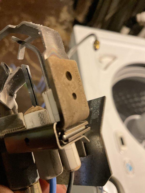 Performed tune-up service on a 24+ year old gas furnace. Inspected electrical connections and Honeywell control components, noting some age-related wear on mounting surfaces. Verified proper operation of switch assembly and wiring integrity during the maintenance procedure.