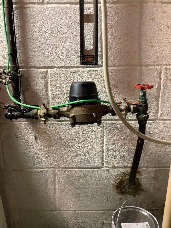 Replaced severely corroded main water valve located approximately 2 feet from meter on cinder block wall. Original valve showed significant deterioration and was estimated to be 10-40 years old. Installed new brass valve with proper fittings to ensure reliable water shut-off capability and prevent potential failure of the aging system.