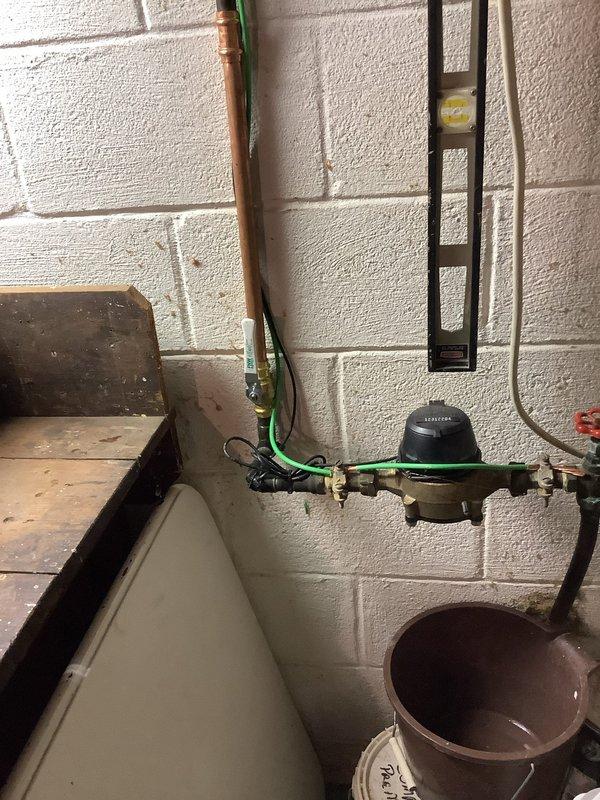 Replaced severely corroded main water valve located approximately 2 feet from meter on cinder block wall. Original valve showed significant deterioration and was estimated to be 10-40 years old. Installed new brass valve with proper fittings to ensure reliable water shut-off capability and prevent potential failure of the aging system.