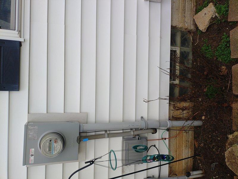 Conducted site assessment for customer-supplied 18kW Generac generator installation with propane fuel source. Evaluated existing electrical panel (approximately 30-40 circuits with main breaker) and exterior meter configuration to determine proper transfer switch location and connection requirements. Documented service entrance setup for future installation planning.