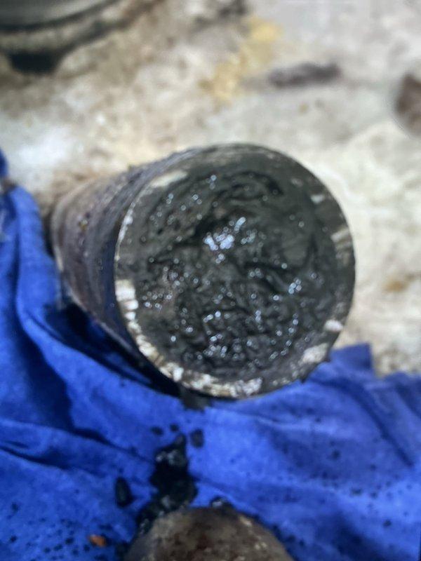 Completed replacement of kitchen drain line in basement area. Removed heavily clogged drain pipe containing significant buildup of sediment and organic waste material. Installed new PVC drain system with proper vertical and horizontal runs, addressing water damage and mold growth at wall/floor junction.