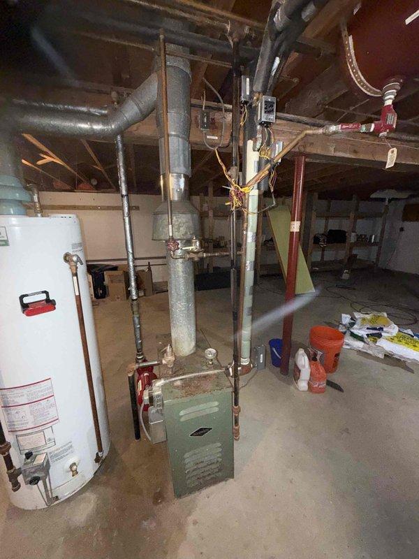 Performed comprehensive boiler tune-up service including inspection of the older model furnace unit and associated ductwork. Examined connections to water heater system and verified proper operation of all control panels and safety devices. Also inspected exterior AC condensing unit, which shows signs of surrounding vegetation encroachment that could potentially affect airflow and efficiency.