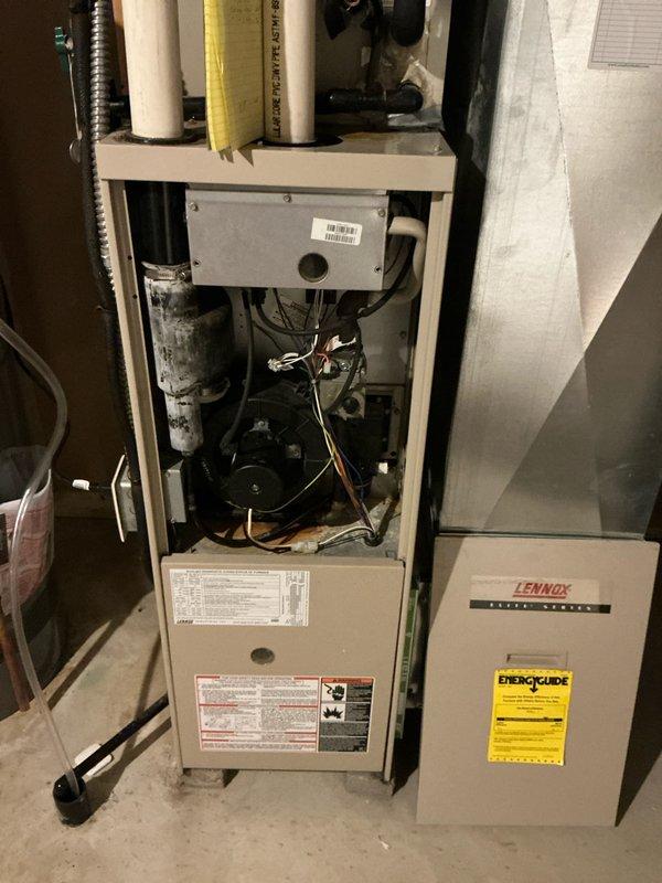 Performed inspection of 24-year-old Lennox HVAC system in utility room. System shows significant age-related wear with open access panels revealing internal components. Documented existing ductwork configuration, gas line connections, and PVC exhaust/intake pipes for proper replacement estimation. Recommended full furnace and air conditioning replacement due to system age and condition.