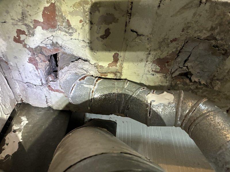 Performed scheduled furnace maintenance tune-up per membership agreement. Inspected interior components after removing access panel, examining motor, electrical wiring and connections. Noted significant wall deterioration and water damage around ductwork installation, with visible cracks and peeling in the surrounding structure that may require attention.