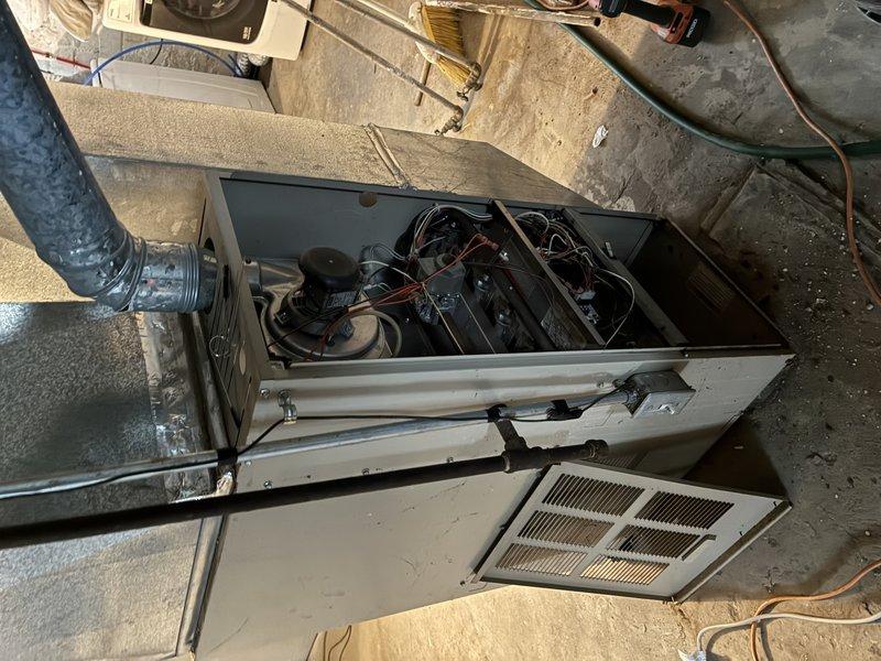 Performed scheduled furnace maintenance tune-up per membership agreement. Inspected interior components after removing access panel, examining motor, electrical wiring and connections. Noted significant wall deterioration and water damage around ductwork installation, with visible cracks and peeling in the surrounding structure that may require attention.