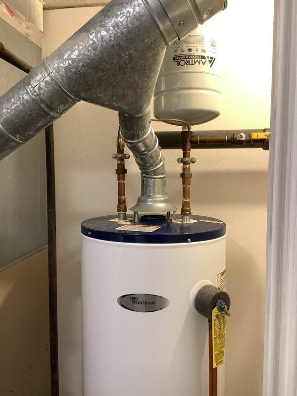 Completed installation of a new Rheem water heater in 25-year-old home, replacing an existing Whirlpool unit. Installation included proper copper pipe connections, ventilation ductwork, and placement of the unit on a leak-protection pan. System was tested and verified to be functioning correctly with all connections secure.