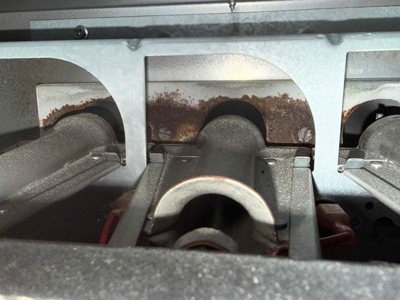 Diagnosed 15-year-old furnace with no heat issue, finding severe rust and corrosion on heat exchanger tubes. Visual inspection revealed significant deterioration of burner assembly and compromised heat transfer fins, indicating end-of-life failure requiring full system replacement rather than repair.