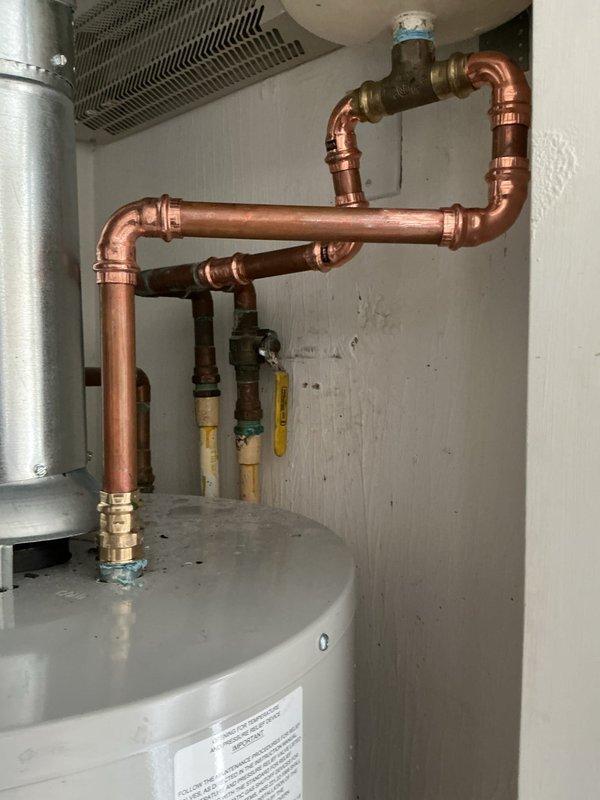 Completed installation warranty service of a tanked water heater system, including copper pipe configuration with multiple joints and connections. Installed expansion tank with proper brass fittings and resolved previous installation balance issue as requested.