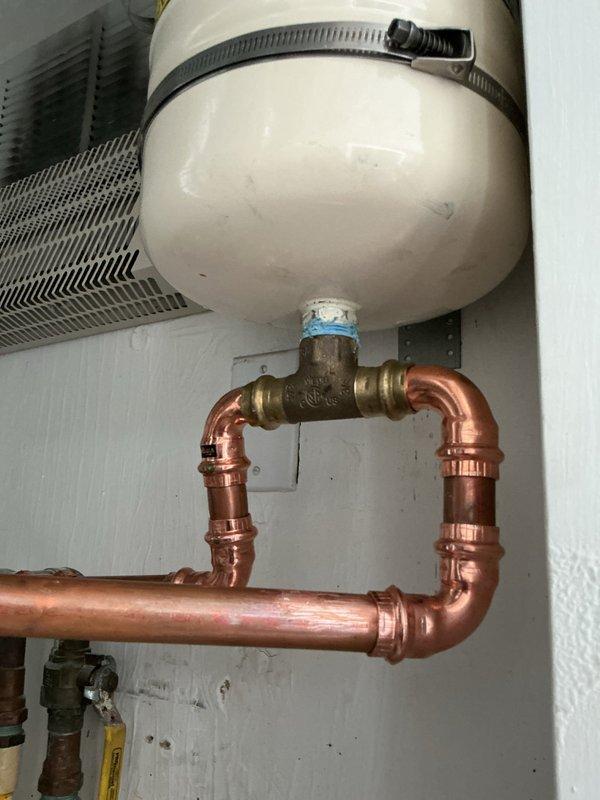 Completed installation warranty service of a tanked water heater system, including copper pipe configuration with multiple joints and connections. Installed expansion tank with proper brass fittings and resolved previous installation balance issue as requested.