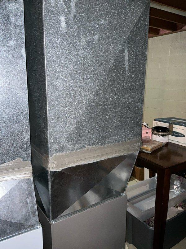 Conducted inspection of existing HVAC system in basement utility area, noting vertical ductwork with damaged insulation and deteriorating galvanized transition components. Examined ceiling infrastructure revealing inadequate support for current system with exposed OSB panels, plumbing lines, and electrical conduits requiring proper accommodation in replacement design. Prepared comprehensive replacement estimate for complete system upgrade.