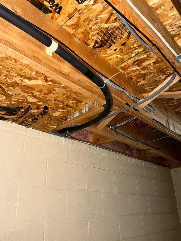 Conducted inspection of existing HVAC system in basement utility area, noting vertical ductwork with damaged insulation and deteriorating galvanized transition components. Examined ceiling infrastructure revealing inadequate support for current system with exposed OSB panels, plumbing lines, and electrical conduits requiring proper accommodation in replacement design. Prepared comprehensive replacement estimate for complete system upgrade.