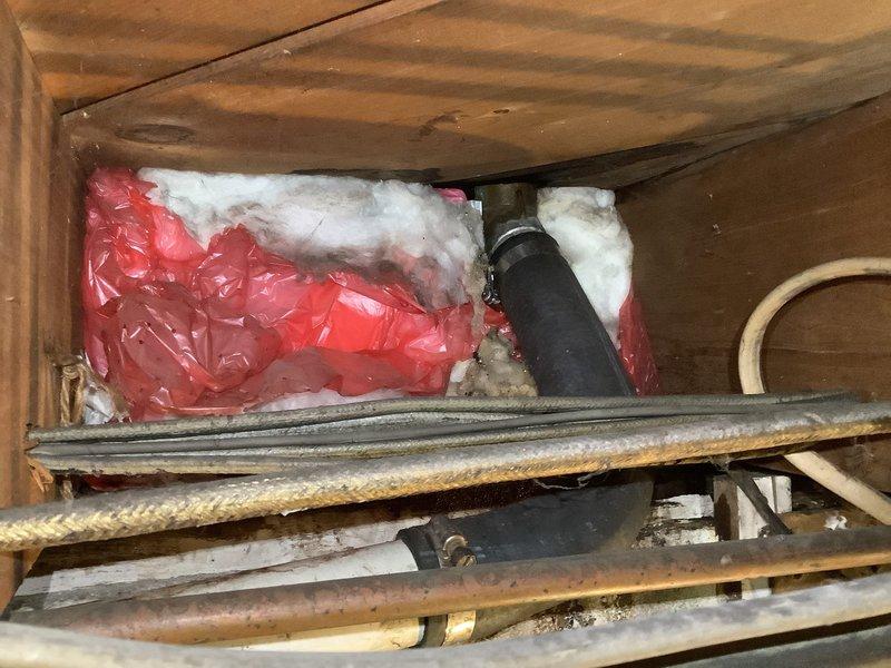 Responded to service call for clogged sink drain in a 60-year-old residence. Upon inspection, discovered significant corrosion on copper supply lines and aging drain pipes in the confined access area. Successfully cleared the blockage and verified proper drainage functionality while documenting the condition of the plumbing system, including areas with verdigris formation and deteriorating insulation that may require future attention.