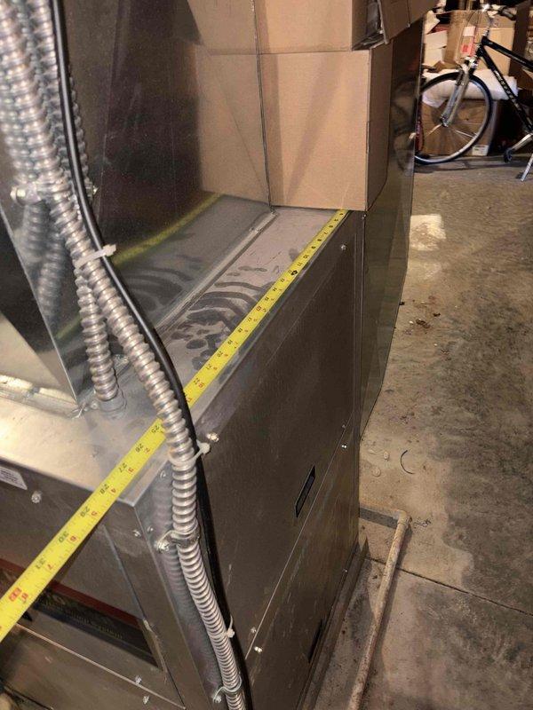 Conducted leak search on existing HVAC system and took measurements of the unit (approximately 3 feet in height) to prepare replacement estimate. System is installed in basement utility area with limited clearance, requiring careful dimensional assessment for proper replacement unit specification.