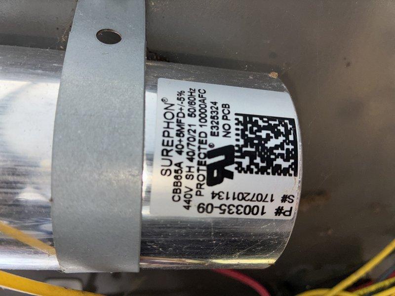 Performed routine A/C tune-up service on outdoor condensing unit. Inspected capacitor (SUREPHLON 40-BMFD-5KH) and found it in working condition. Noted accumulated debris around unit base and condenser coil with moderate dust buildup. Cleaned debris from base and performed standard maintenance checks on system components.