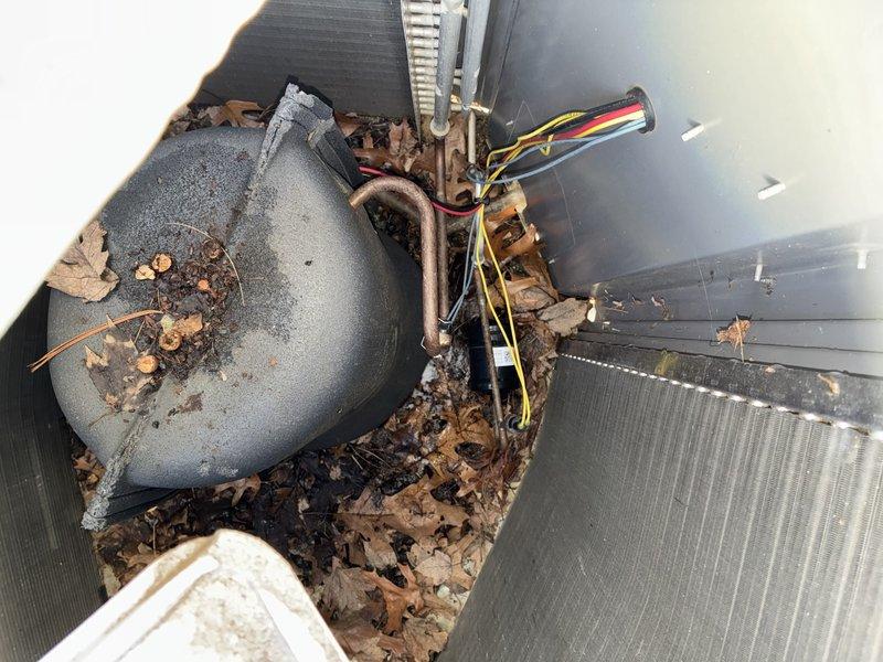 Performed routine A/C tune-up service on outdoor condensing unit. Inspected capacitor (SUREPHLON 40-BMFD-5KH) and found it in working condition. Noted accumulated debris around unit base and condenser coil with moderate dust buildup. Cleaned debris from base and performed standard maintenance checks on system components.