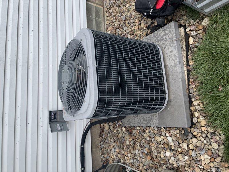 Performed routine maintenance tune-up on 9-year-old outdoor air conditioning unit installed on concrete pad with surrounding decorative river rock. Inspected condenser coil, fan assembly, electrical connections, and verified proper system operation per manufacturer specifications.