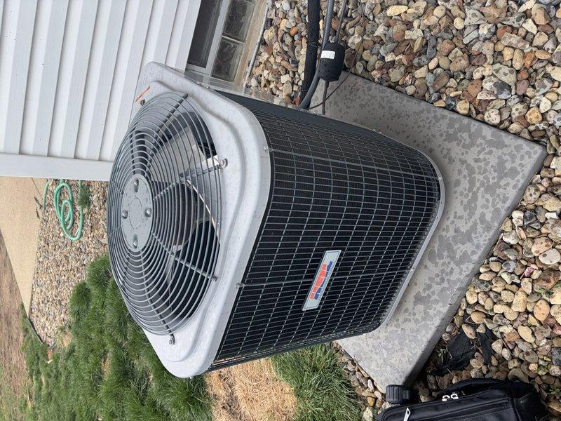 Performed routine maintenance tune-up on 9-year-old outdoor air conditioning unit installed on concrete pad with surrounding decorative river rock. Inspected condenser coil, fan assembly, electrical connections, and verified proper system operation per manufacturer specifications.