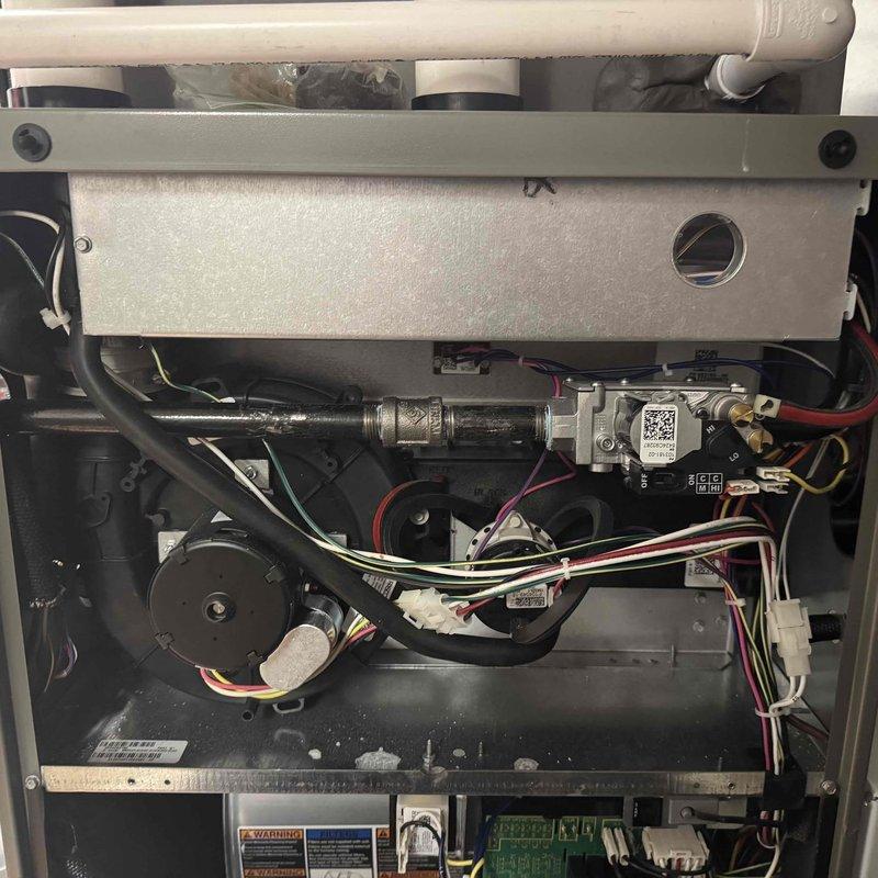Performed scheduled MVP heating maintenance service at commercial site. Inspected boiler/hydronic system components including pressure gauge (reading 80-90 PSI), pressure regulator, and associated valves and piping. Examined furnace interior components including blower motor, gas valve assembly, control board, and wiring connections - all components functioning properly with no issues identified.